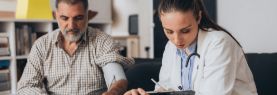 Doctora apuntando datos durante consulta con paciente